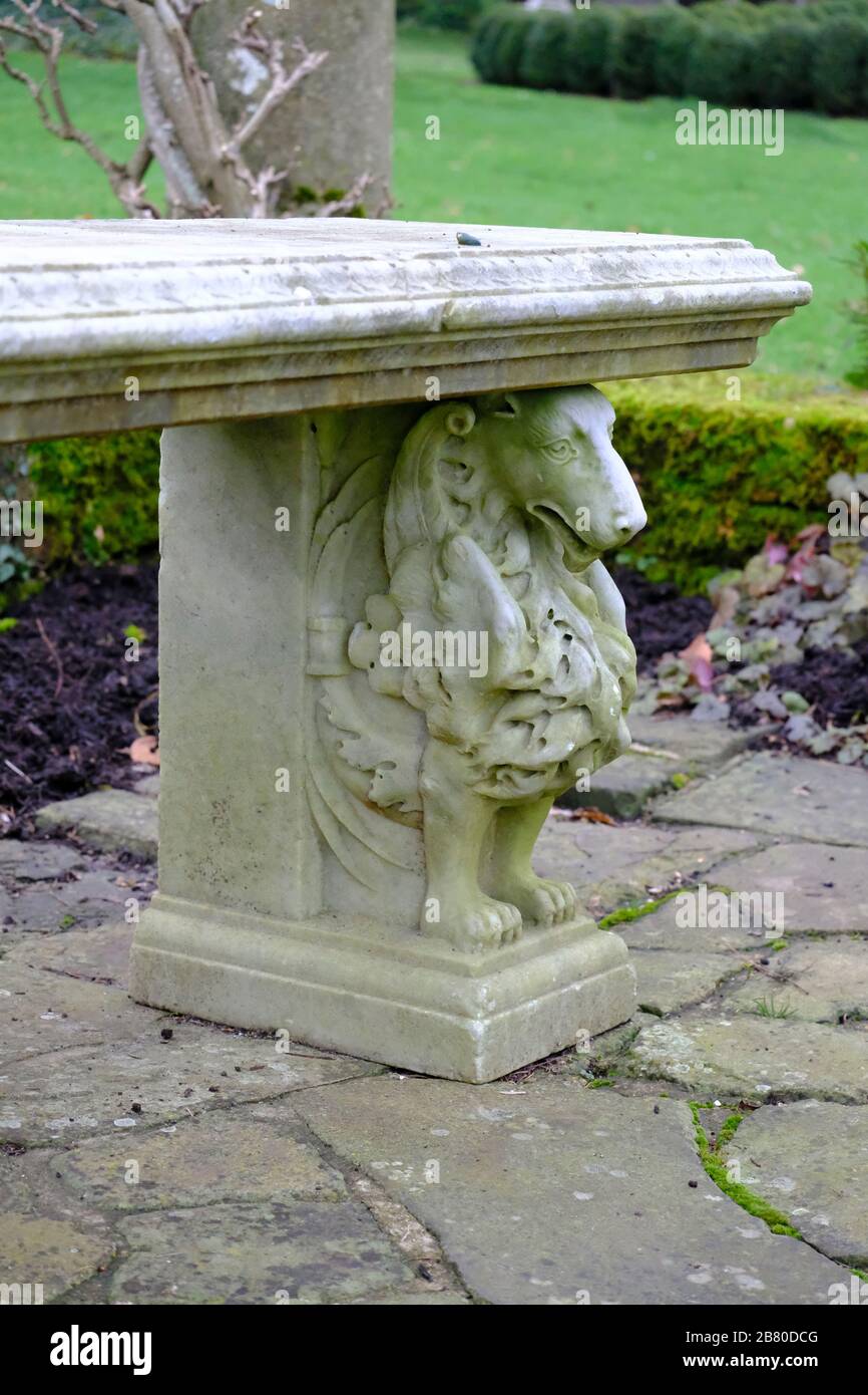 Un extremo de un banco decorativo del jardín del león de la piedra Foto de stock