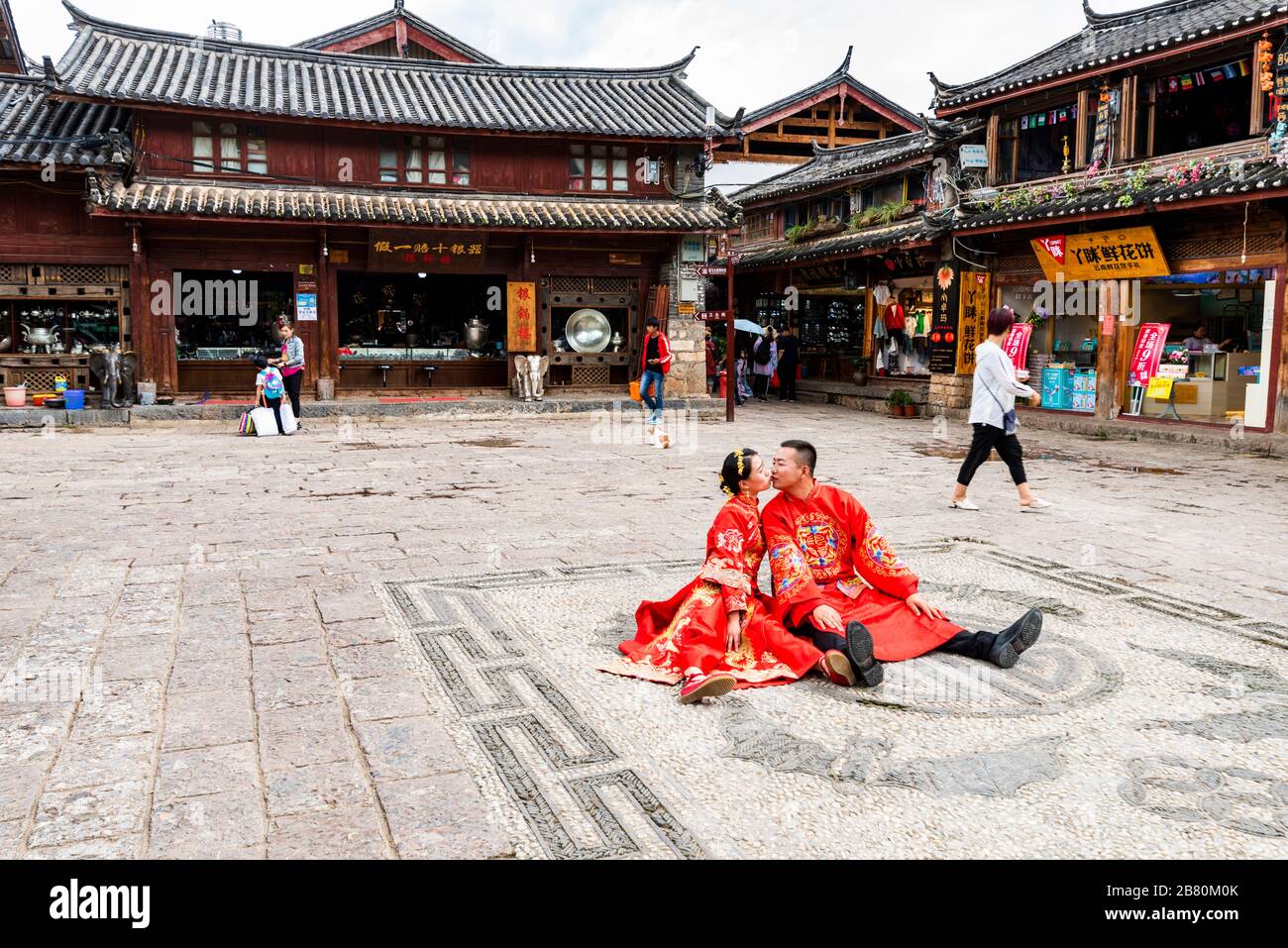 Una pareja recién vestida con trajes tradicionales posando para fotos de boda en la antigua ciudad de Shuhe cerca de Lijiang, provincia de Yunnan, China. Foto de stock