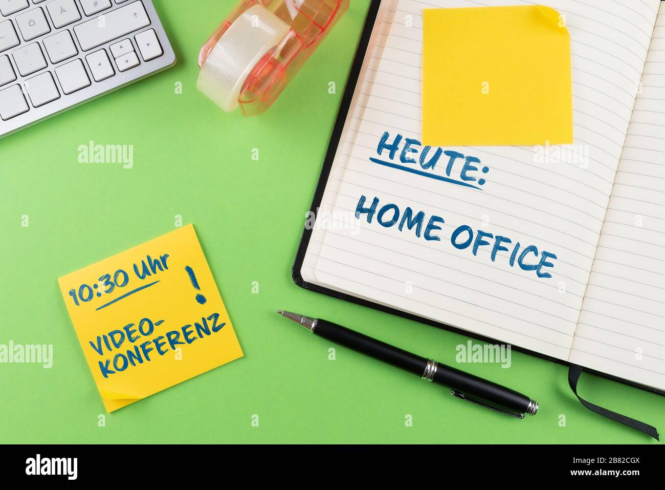 Concepto de trabajo desde casa y oficina doméstica, portátil y bloc de notas en el escritorio con recordatorio de videoconferencia en alemán Foto de stock