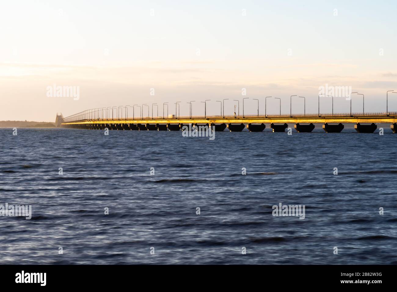 El Puente de Oland se ilumina al sol en color dorado, conectando la isla de Oland con el territorio continental de Suecia Foto de stock