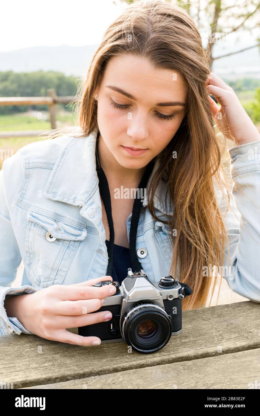 Extremistas Ingenioso péndulo una mujer joven con cámara fotográfica realiza ajustes en la cámara  Fotografía de stock - Alamy