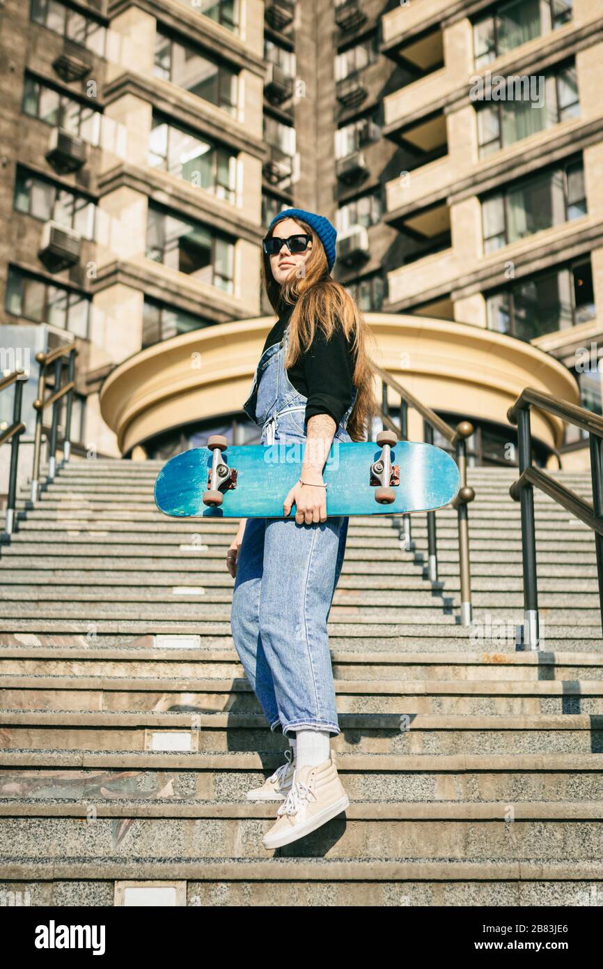Mujer urbana con skate. Hipster chica con monopat n en la ciudad