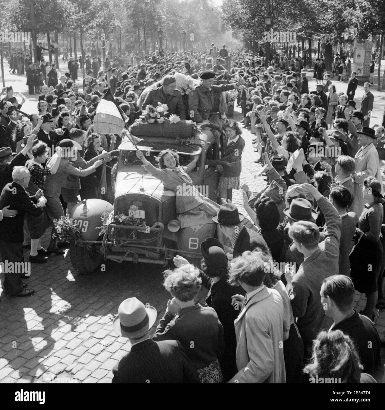 Los civiles celebran la entrada de vehículos británicos en Bruselas, el 4 de septiembre de 1944. Foto de stock