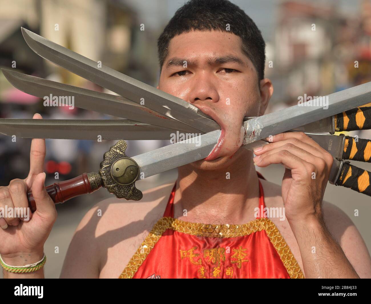 El joven devoto Taoista Chino Tailandés le clavará la mejilla izquierda con  tres cuchillos largos y una espada durante el Festival Vegetariano de  Phuket Fotografía de stock - Alamy