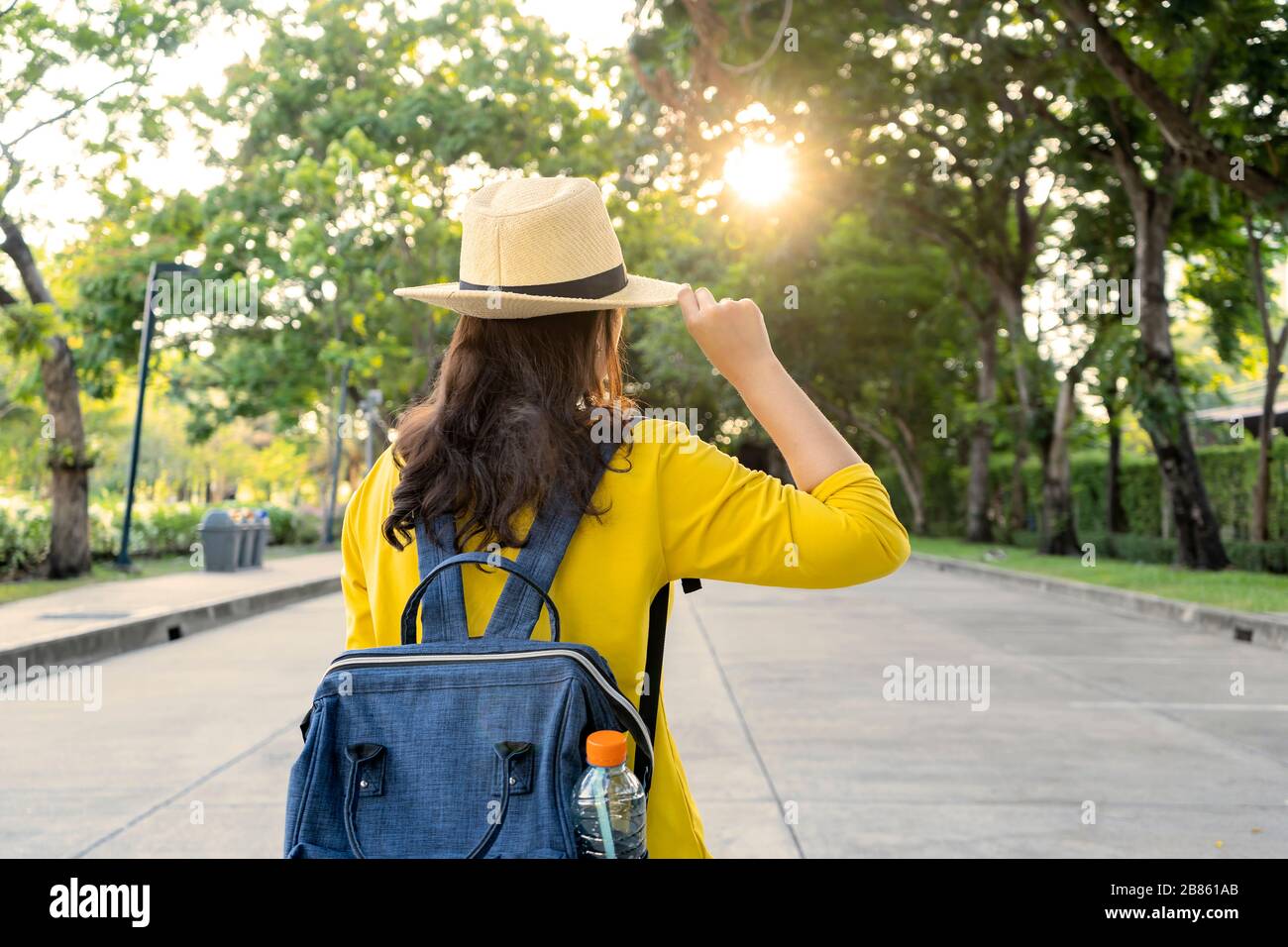 Hermosos jóvenes turistas asiáticos, camisas amarillas, sombreros de paja, mochilas que viajan en un parque en Tailandia. Ella tiene mucha pasión y felicidad. Foto de stock