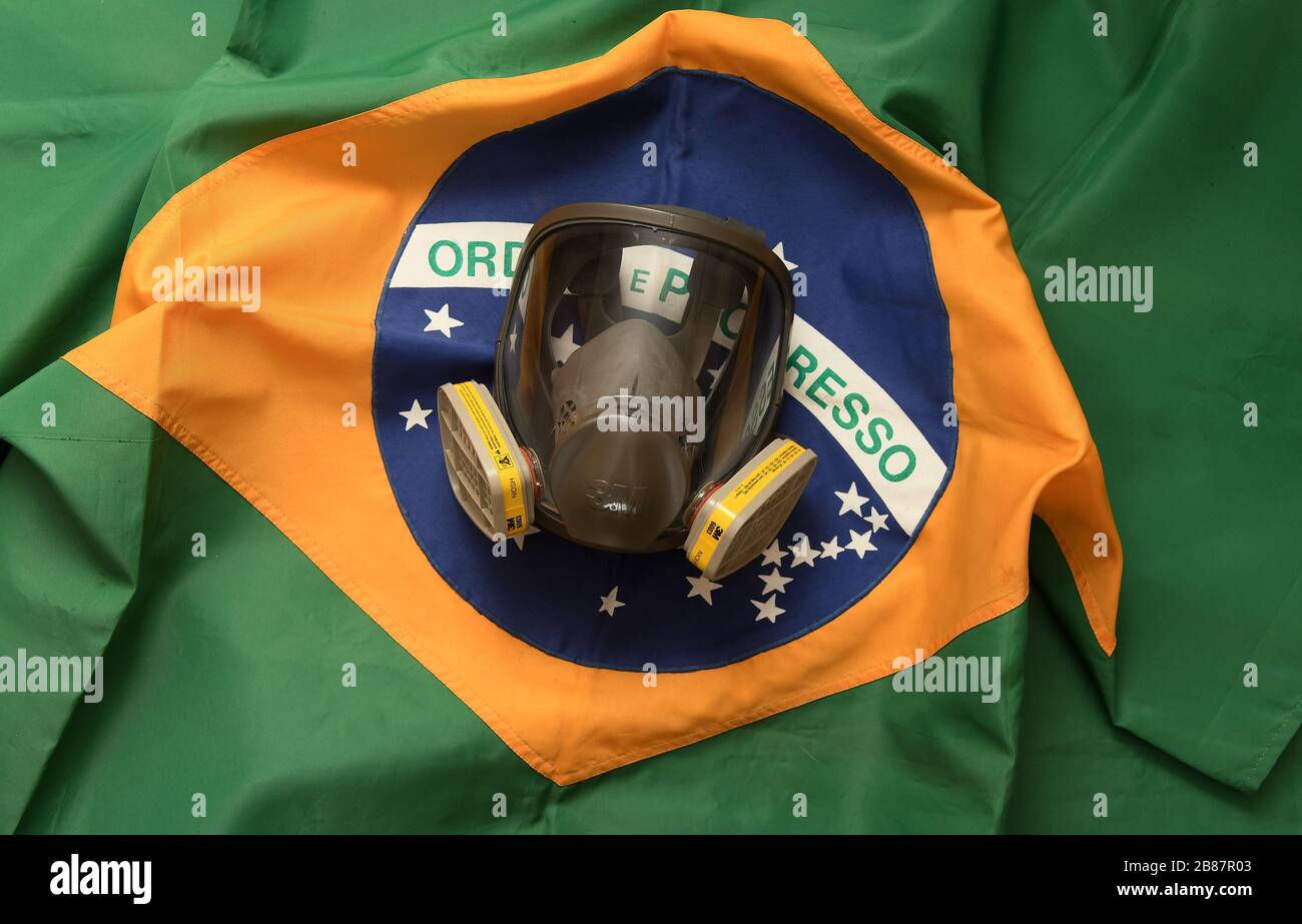 Río de Janeiro, Brasil, 20 de marzo de 2020. Máscara de protección facial contra gases y olores con bandera brasileña en el fondo. Foto de stock