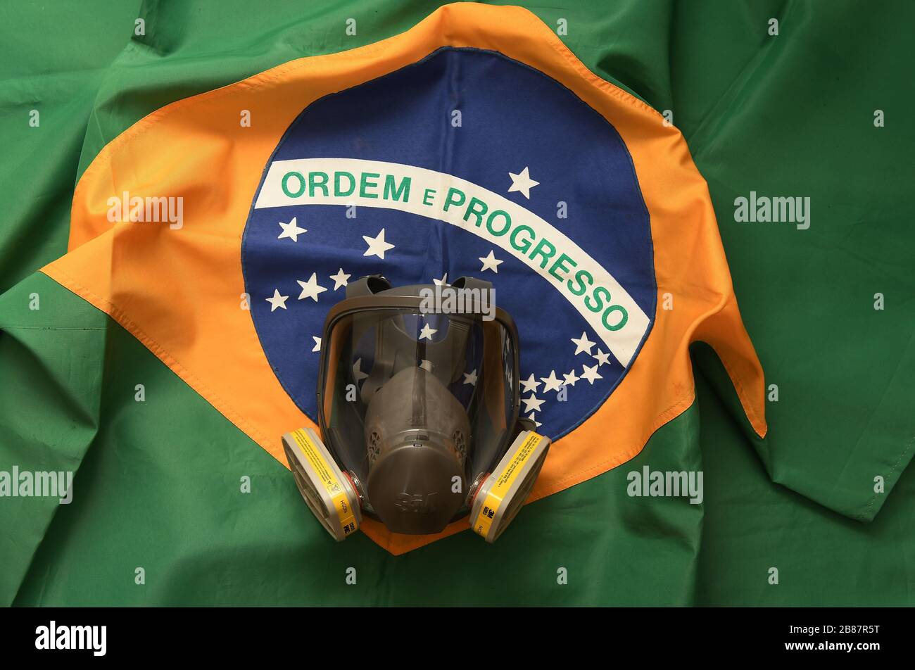 Río de Janeiro, Brasil, 20 de marzo de 2020. Máscara de protección facial contra gases y olores con bandera brasileña en el fondo. Foto de stock