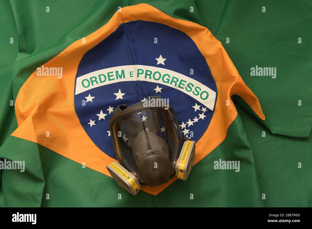 Río de Janeiro, Brasil, 20 de marzo de 2020. Máscara de protección facial contra gases y olores con bandera brasileña en el fondo. Foto de stock
