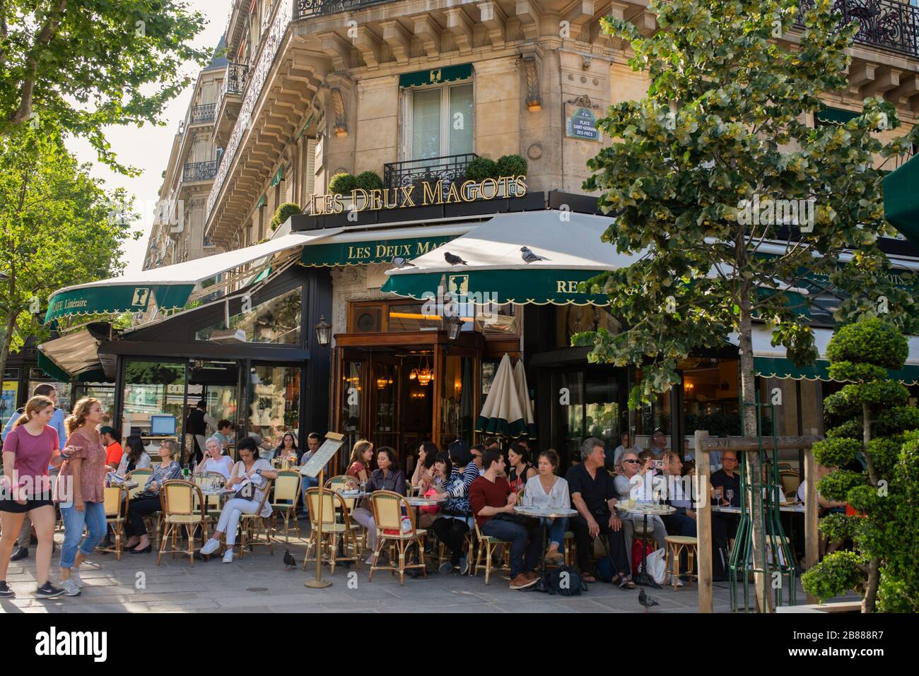 El famoso café Les Deux magots situado en la zona parisina de Saint Germain des Pres; soleado día de verano en París. Gente sentada en el café francés afuera Foto de stock