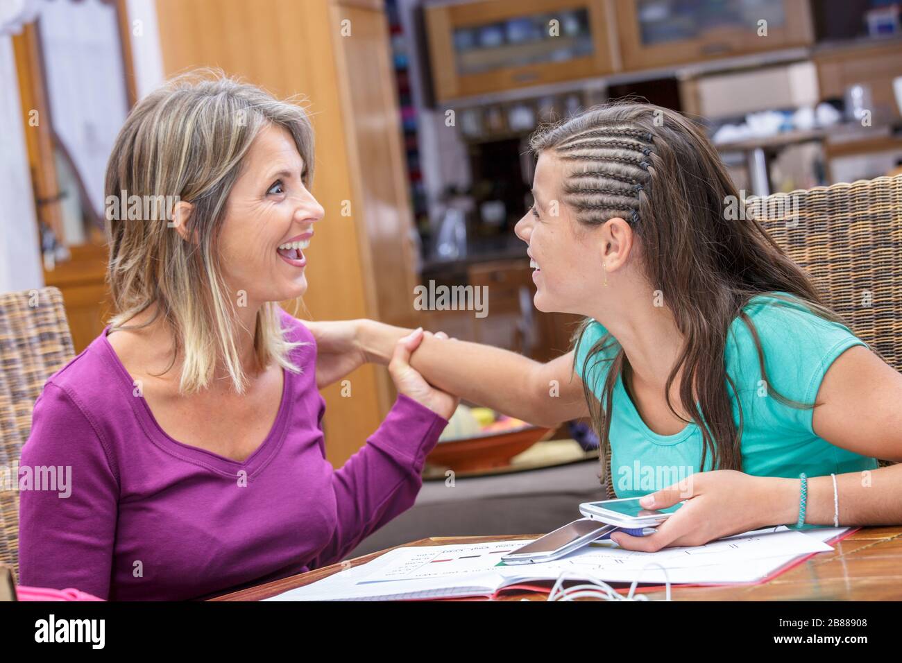 madre e hija compartiendo un momento de complicidad y risa Foto de stock