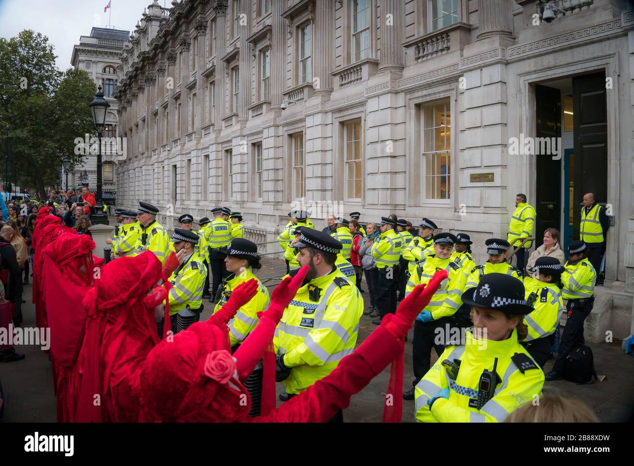 Whitehall, Londres, Reino Unido. - El 7 de octubre de 2019- XR ptotests - "Brigada Roja" grupo de arte durante un espectáculo de calle en frente de la Oficina del Gabinete Foto de stock