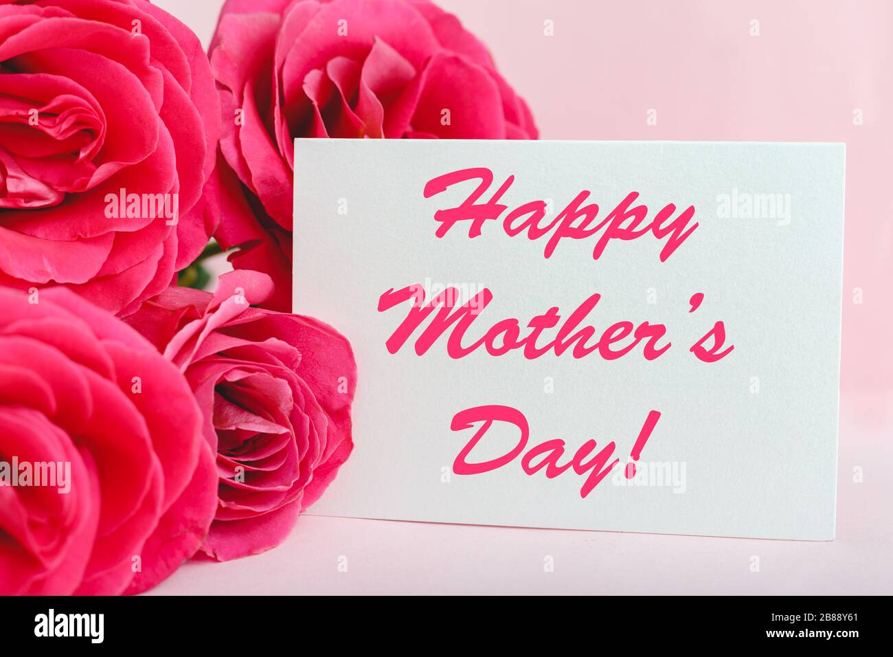 Feliz día de las madres texto en tarjeta de regalo en ramo de flores de rosas  rosas en fondo rosa. Tarjeta de felicitación para mamá. Florerias, tarjeta  de felicitaciones Fotografía de stock -