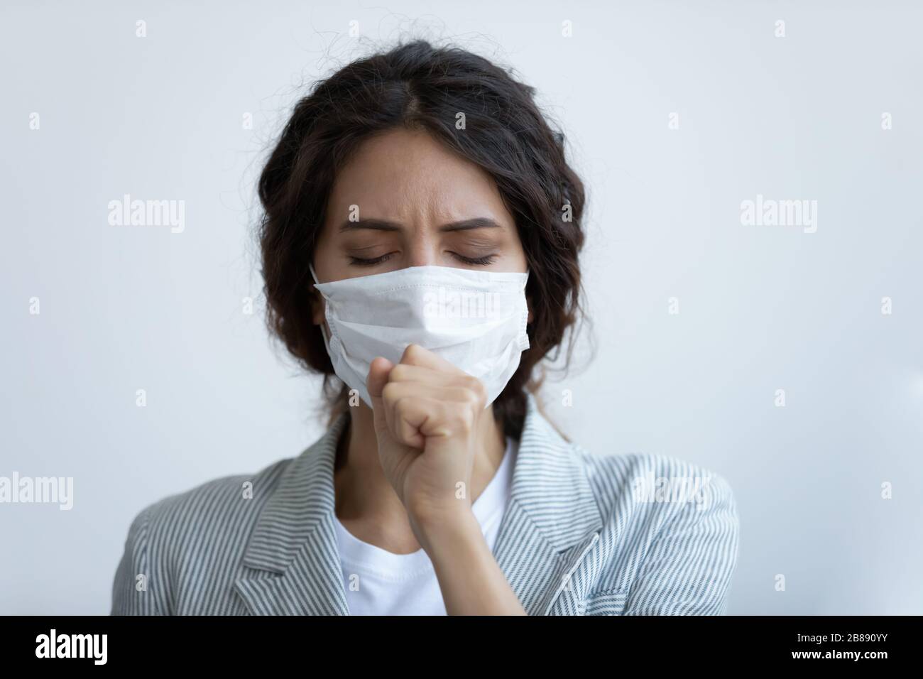 Mujer malsana en la máscara tosiendo con síntomas de la enfermedad del coronavirus Foto de stock