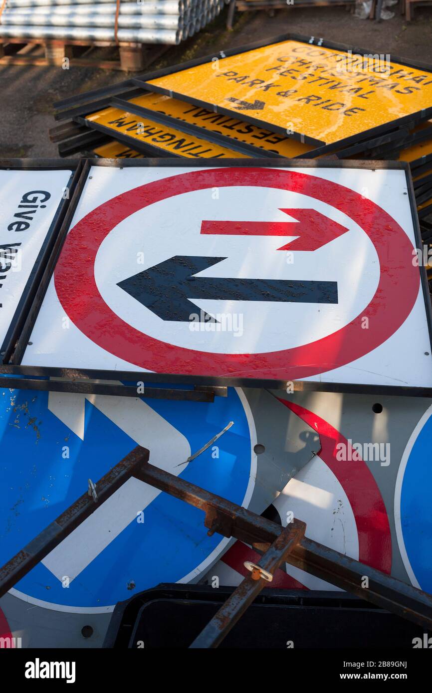 Varios carteles metálicos británicos de carretera en el recinto de almacenamiento en espera de uso. Foto de stock