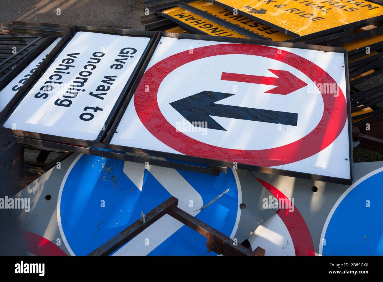 Varios carteles metálicos británicos de carretera en el recinto de almacenamiento en espera de uso. Foto de stock