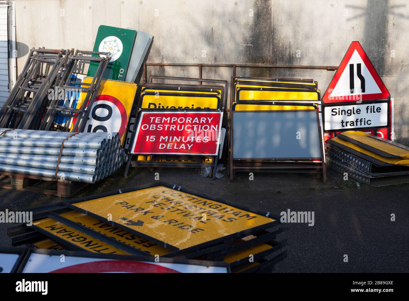 Varias señales metálicas de carreteras británicas, entre las que se incluyen "obstrucción temporal de 15 minutos de retraso" en el complejo de almacenamiento en espera de uso. Foto de stock