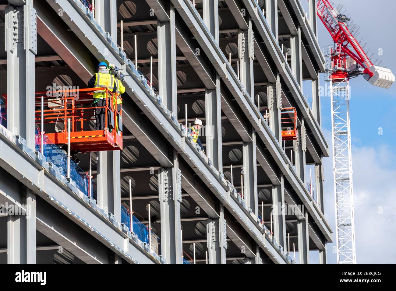 Los trabajadores de la construcción en Glasgow siguen trabajando a través del brote de Coronavirus en Escocia, incluso cuando otros negocios cierran. Foto de stock