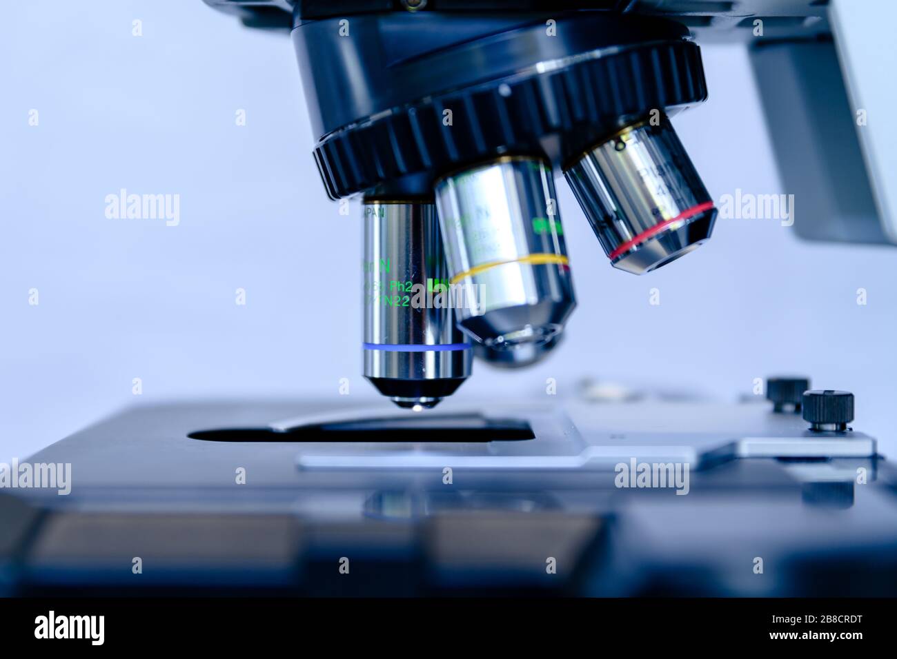 Un microscopio de luz de primer plano para la investigación de biociencias farmacéuticas. Concepto de ciencia, laboratorio y estudio de enfermedades. Tratamiento con coronavirus (COVID-19) Foto de stock