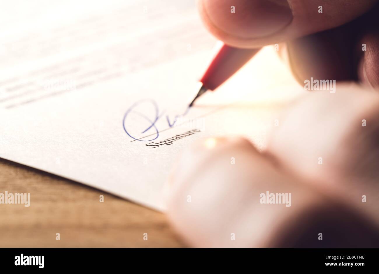 Hombre escribiendo firma con bolígrafo sobre papel. Liquidación para adquisición, negocio, préstamo bancario o alquiler de apartamento. Firma de contrato, acuerdo. Foto de stock