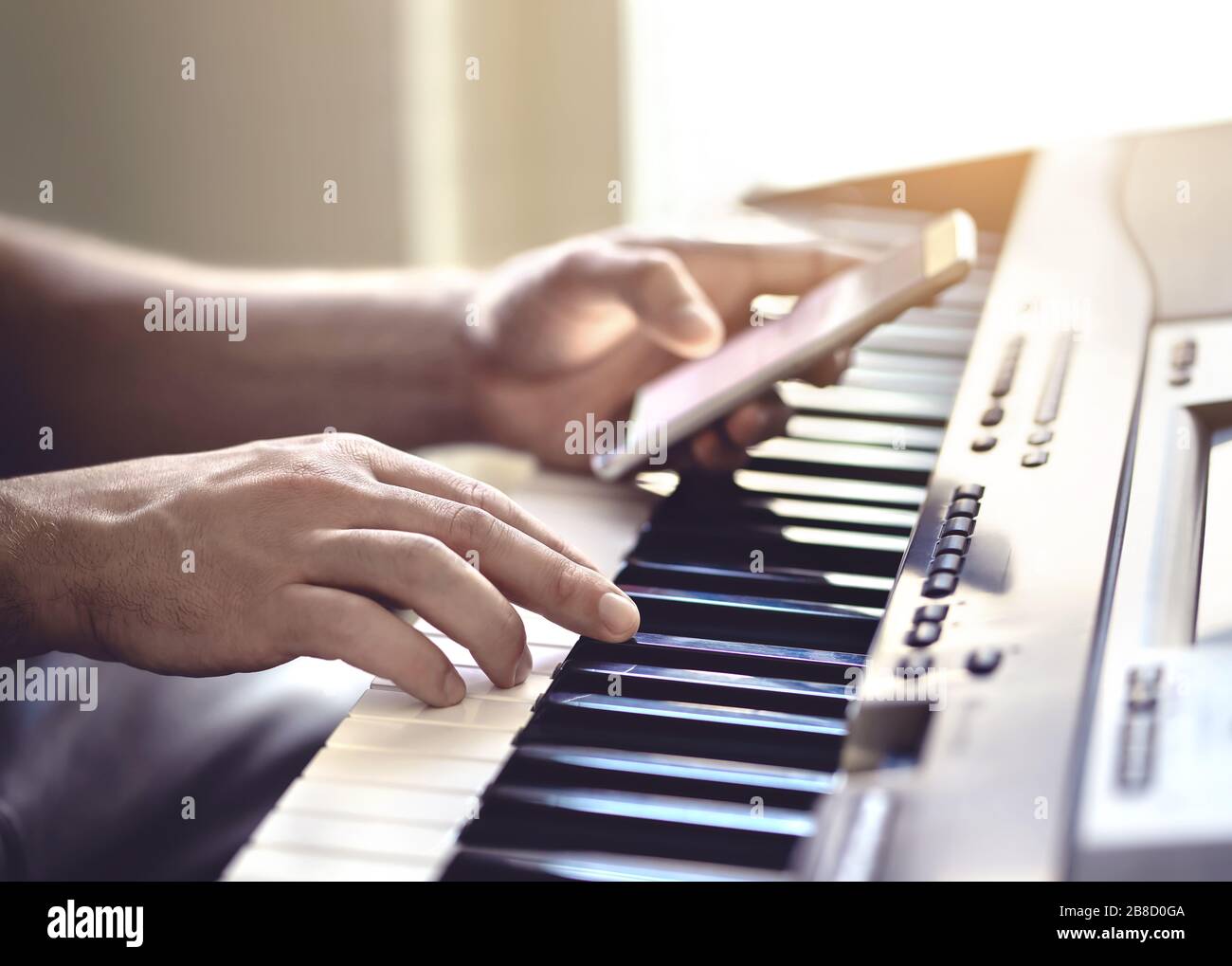 Hombre tocando piano y usando el teléfono móvil. Persona que graba sonido,  lee notas de la pantalla del smartphone o escribe letras para una canción  Fotografía de stock - Alamy