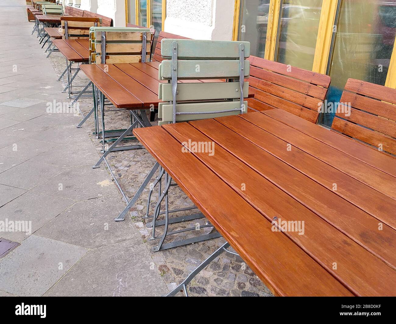 Sillas y mesas al aire libre desiertas de un restaurante de la calle en el barrio berlinés de Friedrichshain, durante el cierre de coronavirus en Alemania. Foto de stock