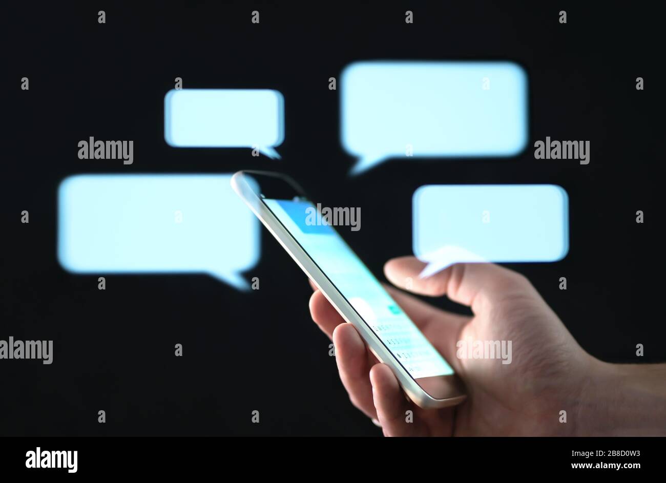Mensajes de texto en la pantalla del teléfono celular con burbujas abstractas del discurso del holograma. Aplicación de mensajería instantánea. Texto, chat en grupo, sexting o concepto de sms. Foto de stock