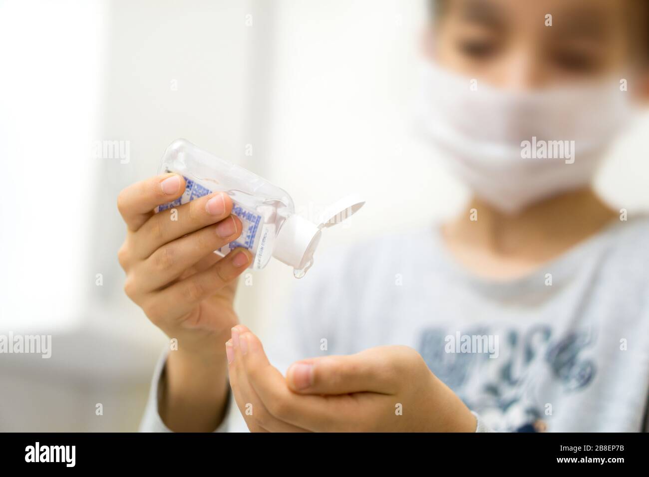 persona que usa mascarilla de respiración y loción para la limpieza de manos Foto de stock