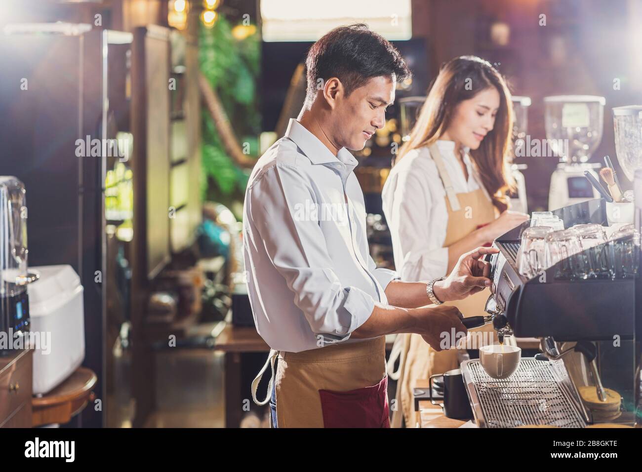 Asiático Barista preparando una taza de café, espresso con latte o  capuchino para el pedido del cliente en la cafetería, haciendo espresso,  propietario de Una Pequeña empresa y s Fotografía de stock -