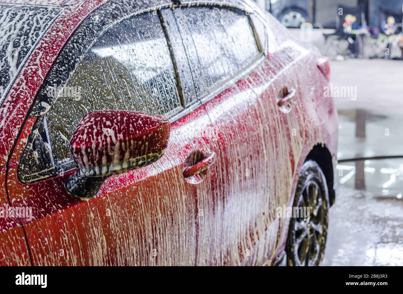Servicio de limpieza de coches. Coche rojo moderno con espuma en el cuidado  del carro Fotografía de stock - Alamy