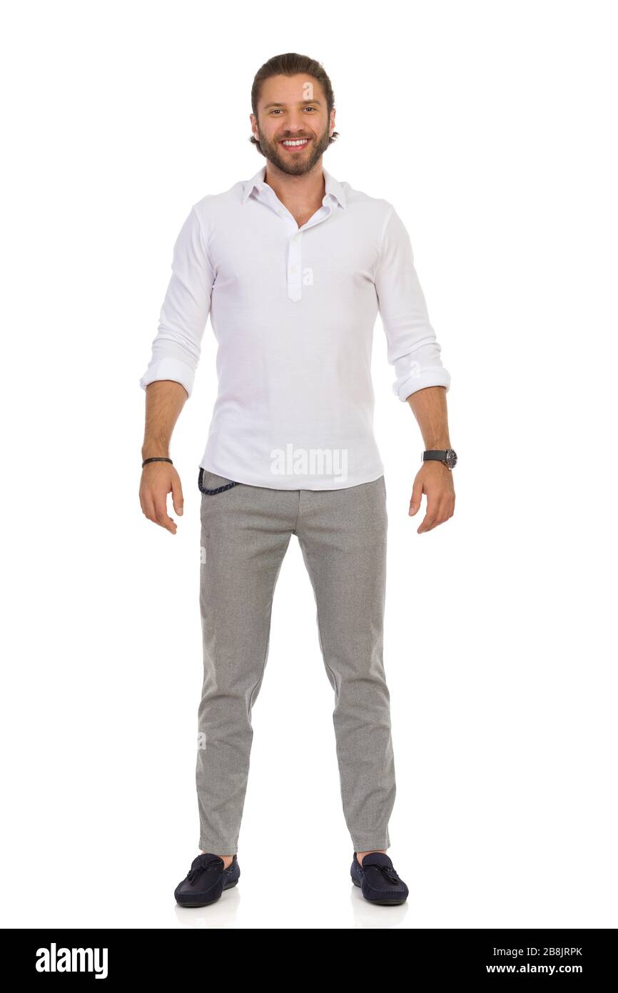 Un hombre elegante y guapo en mocasines, pantalones grises y camisa blanca está parado relajado. Vista frontal. Estudio completo aislado sobre blanco Fotografía de stock - Alamy
