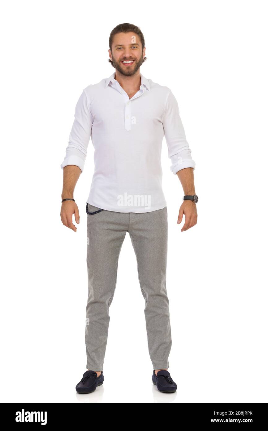 Un hombre elegante y guapo en mocasines, pantalones grises y camisa blanca  está parado relajado. Vista frontal. Estudio completo aislado sobre blanco  Fotografía de stock - Alamy