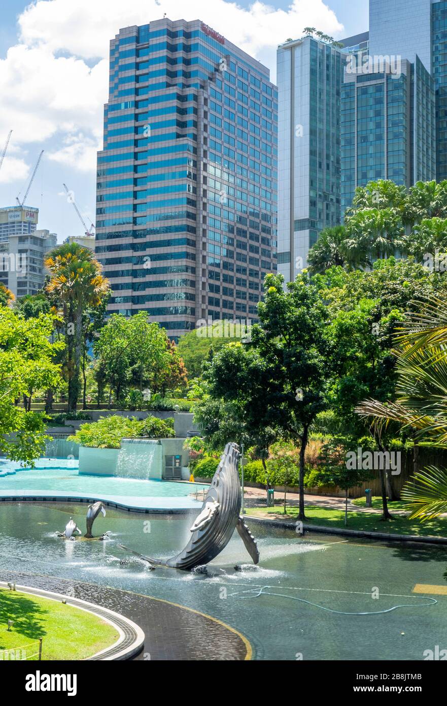 Torres de oficinas y fuente de escultura de ballenas en el Lago Symphony en el Parque KLCC Kuala Lumpur Malasia. Foto de stock