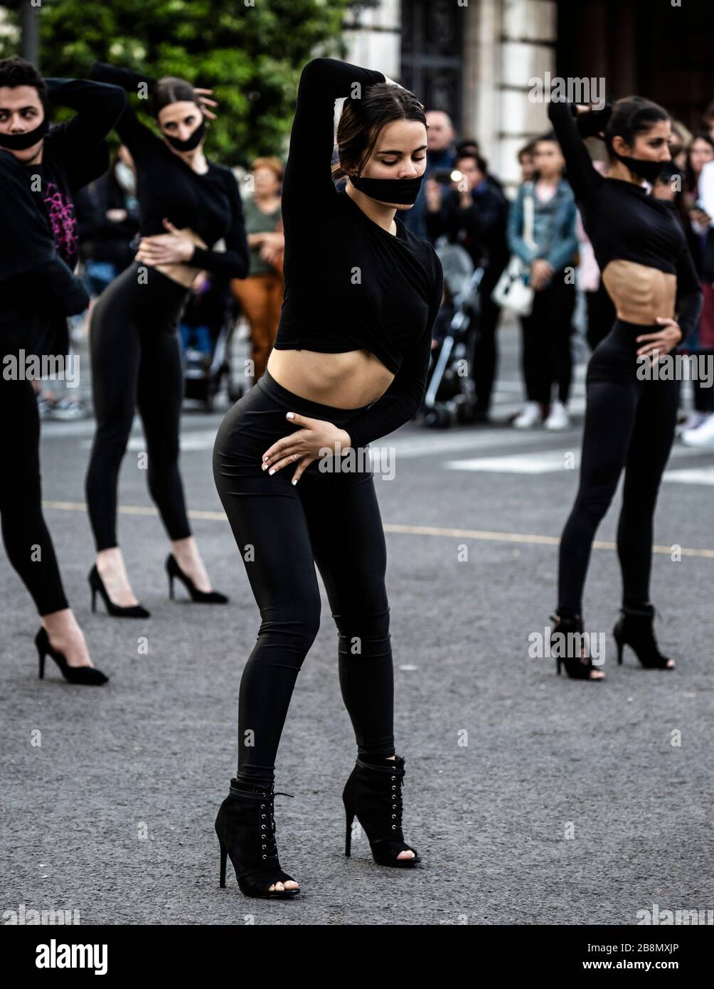 Grupo de baile vestido de negro con máscaras de cara sobre la boca, día Internacional de la Mujer 2020, Valencia, España. Foto de stock