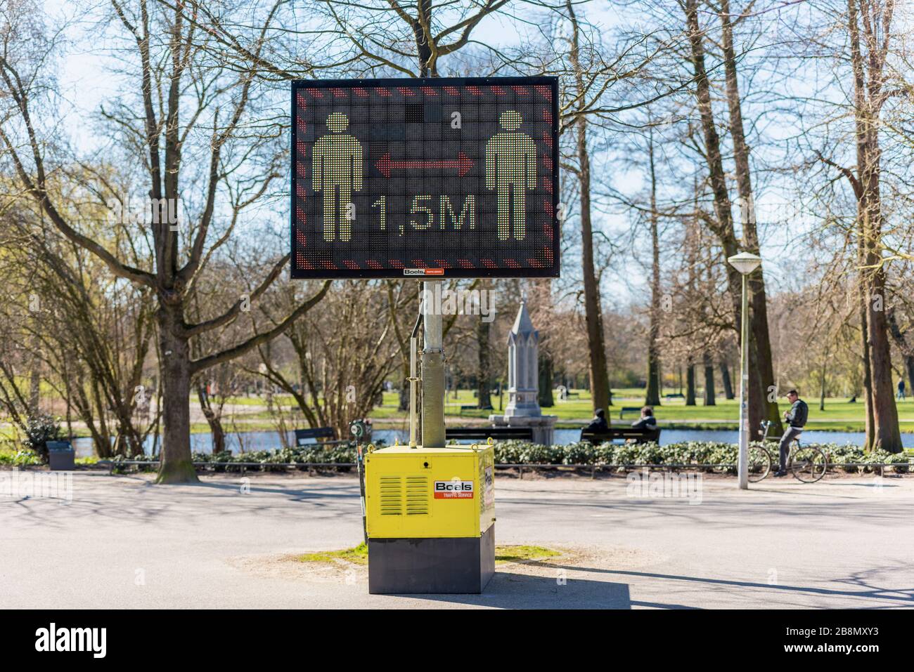 Mantenga una distancia de 1.5 metros señal de advertencia en la pantalla digital en un parque público, recordando a las personas de distanciamiento social y evitando la propagación del coronavirus Foto de stock