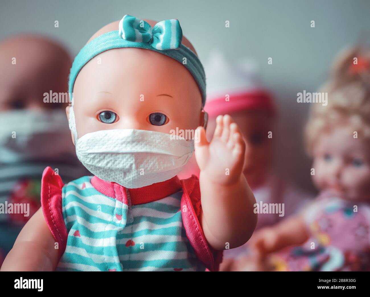 Confiar anfitriona Giro de vuelta Una muñeca bebé que representa la seguridad usando una máscara para evitar  el contagio con otras muñecas detrás Fotografía de stock - Alamy