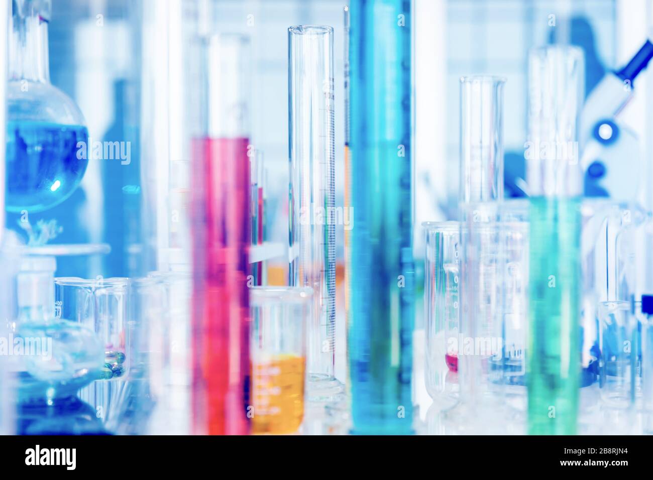 Tubos de vidrio utilizados en laboratorios científicos, fondo azul claro Foto de stock