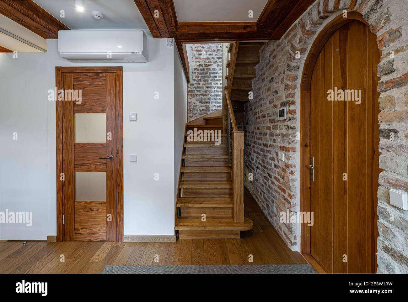 Loft moderno interior del apartamento. Vestíbulo de entrada. Escalera de  madera. Pared de ladrillo. Casa privada Fotografía de stock - Alamy