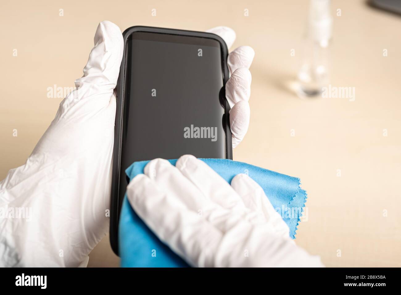 Limpieza de la pantalla del smartphone con alcohol. Concepto de limpieza de pantalla sucia para la prevención de enfermedades del virus COVID-19 Coronavirus Foto de stock