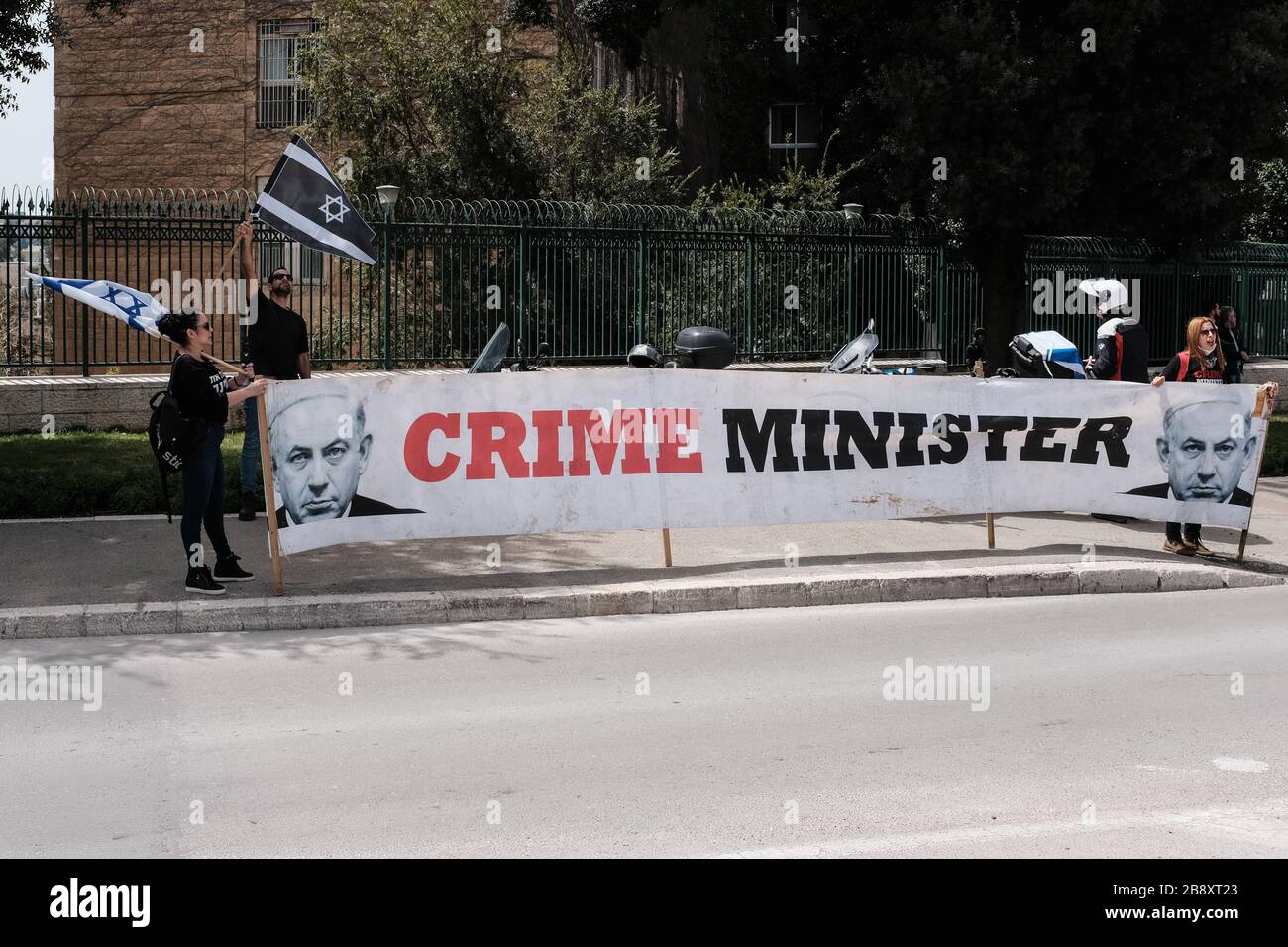 Jerusalén, Israel. 23 de marzo de 2020. El Movimiento de las Banderas Negras lleva un convoy de más de 1,000 coches al Knesset, el Parlamento israelí, agitando banderas israelíes y negras, protestando por el supuesto intento del gobierno de Netanyahu de manipular la legislación y abusar de las medidas de emergencia contra el Coronavirus en un intento de "secuestrar" la democracia por beneficios políticos y personales. Actualmente se está apelando a la Corte Suprema con el objetivo de restablecer el pleno poder del Parlamento, bloqueado por el presidente del Knesset, Edelstein, un aliado de Netanyahu. Crédito: NIR Alon/Alamy Live News Foto de stock