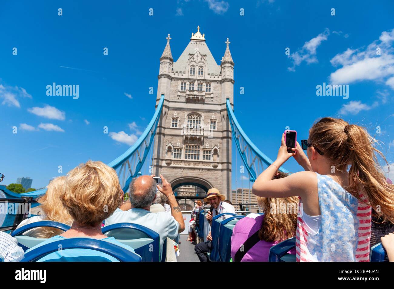 Los turistas en open top double decker Original London Sightseeing Tour bus cruzando el puente de la torre, Londres, Reino Unido. Foto de stock