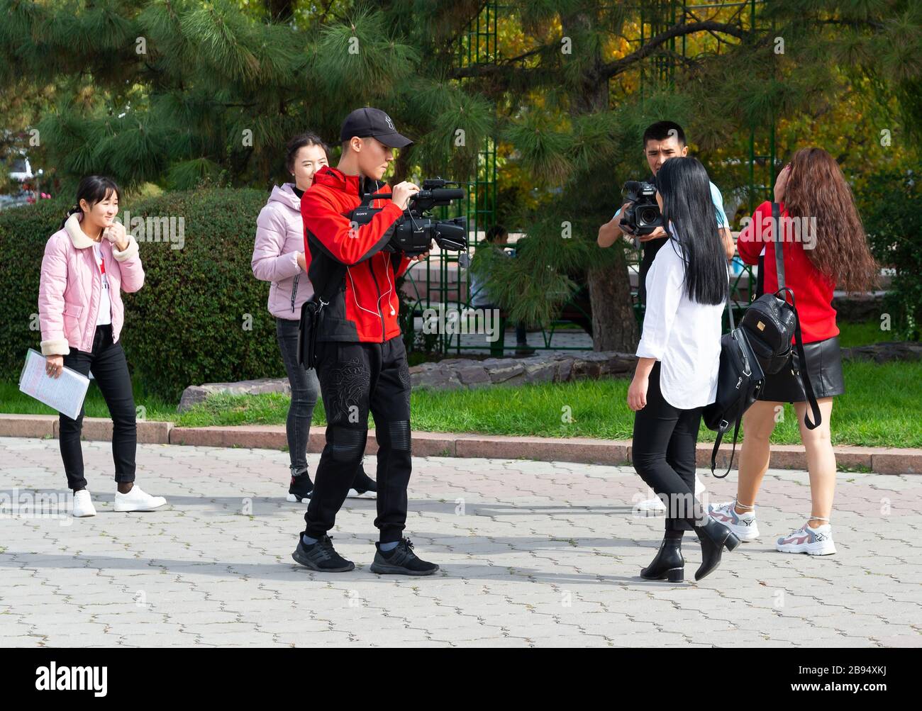 Grupo de jóvenes estudiantes de Bishkek, Kirguistán, trabajando en un proyecto cinematográfico para clase con dos cámaras de grabación. Adolescentes en Asia Central. Foto de stock