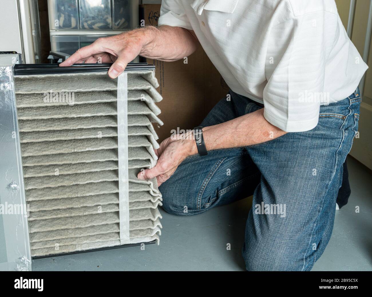 Hombre caucásico mayor cambiando un filtro de aire sucio plegado en el  sistema de calefacción, ventilación y aire acondicionado en el sótano de la  casa Fotografía de stock - Alamy