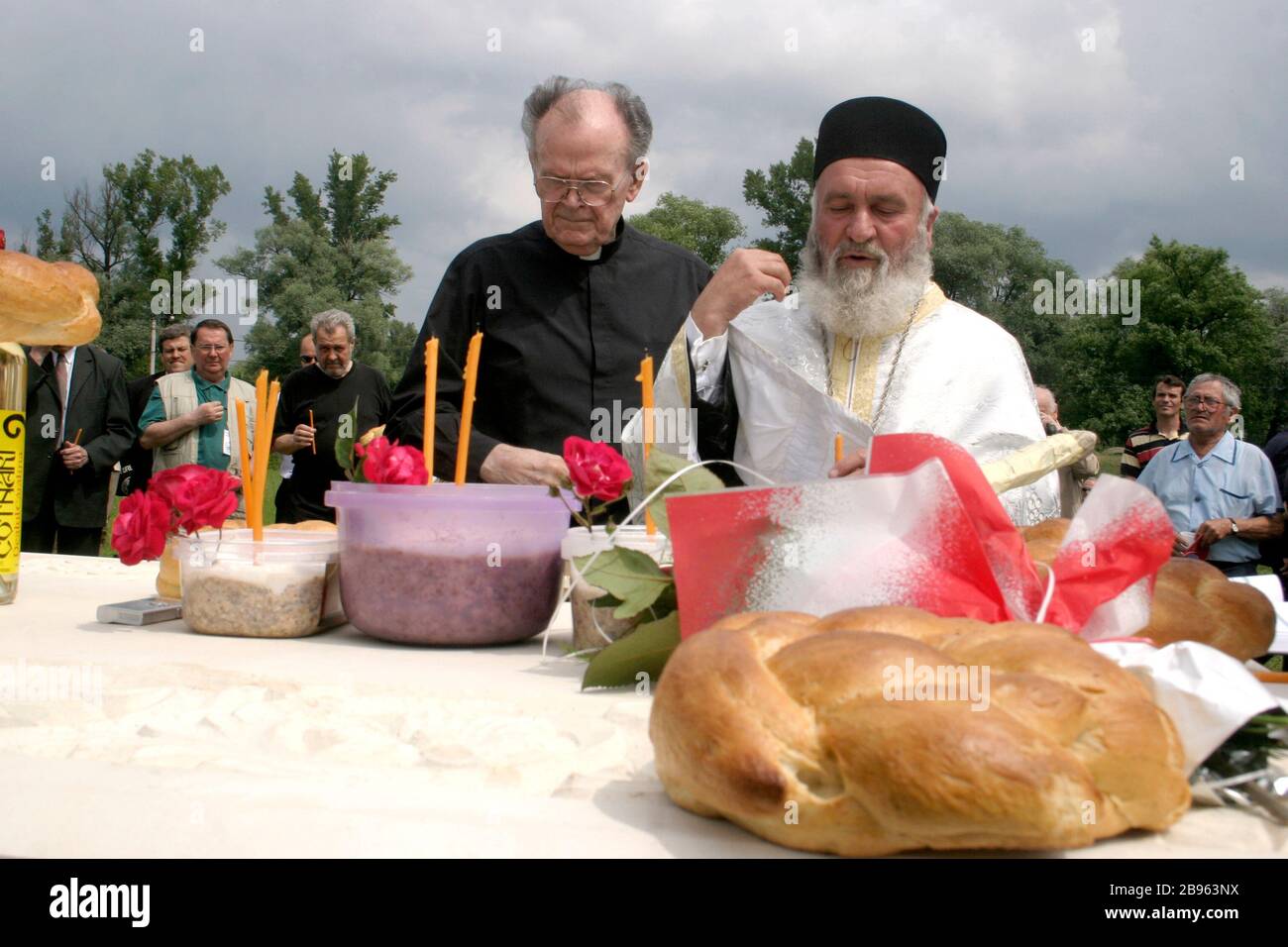 Sacerdote ortodoxo y pastor católico que mantiene un servicio religioso en memoria de las víctimas del comunismo en Sighet, Rumania Foto de stock