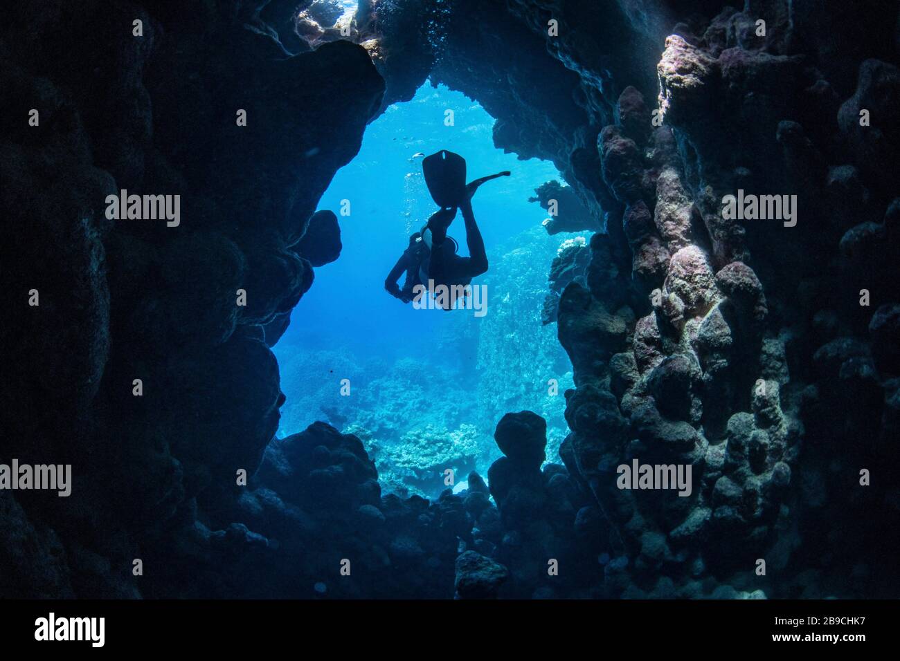 Un buceador sale de una cueva submarina, el Mar Rojo. Foto de stock