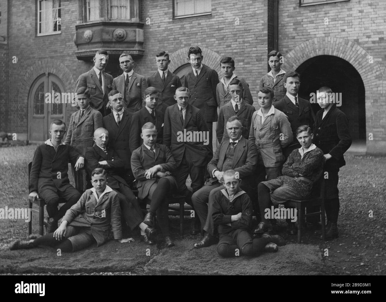 Veinte graduados de la escuela secundaria se encuentran alrededor del