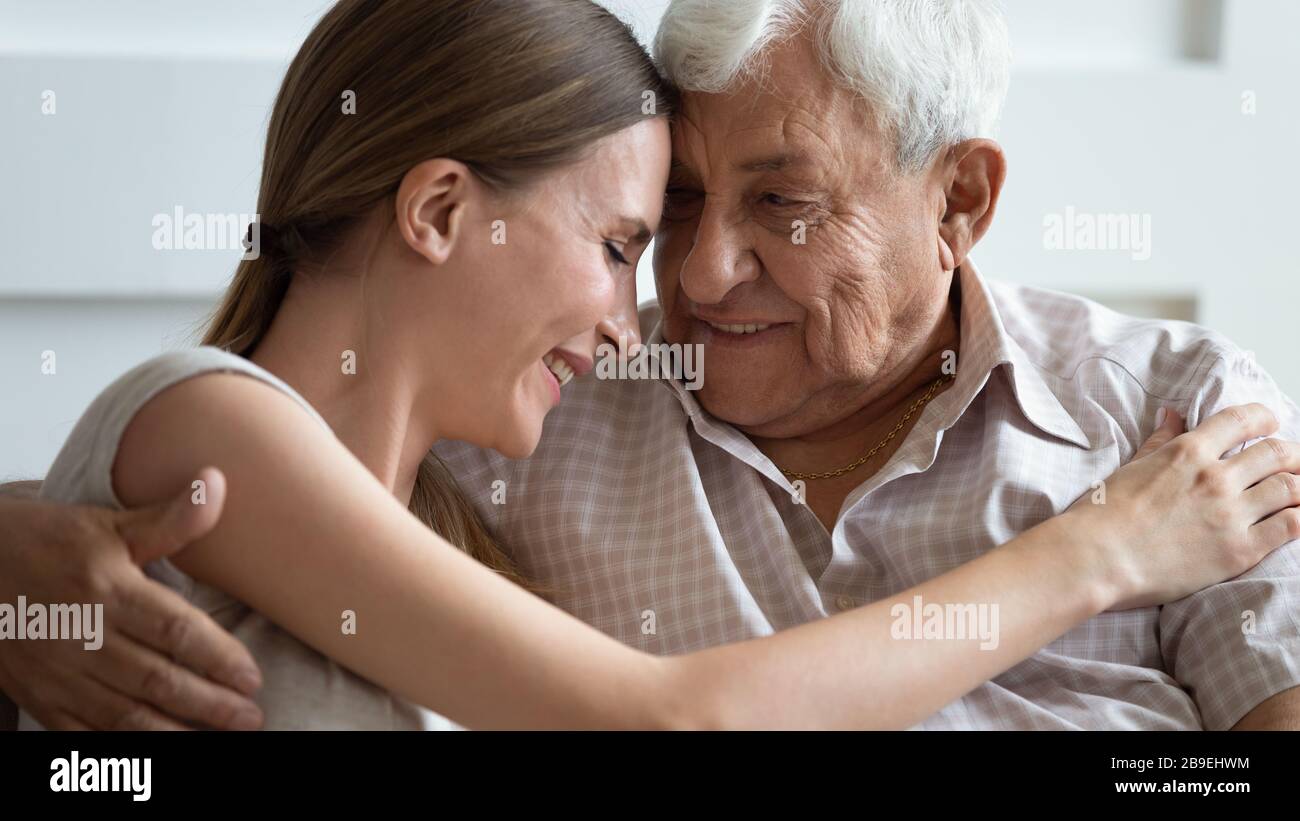 Amando a la hija adulta y al padre mayor tocando frentes, amando Foto de stock