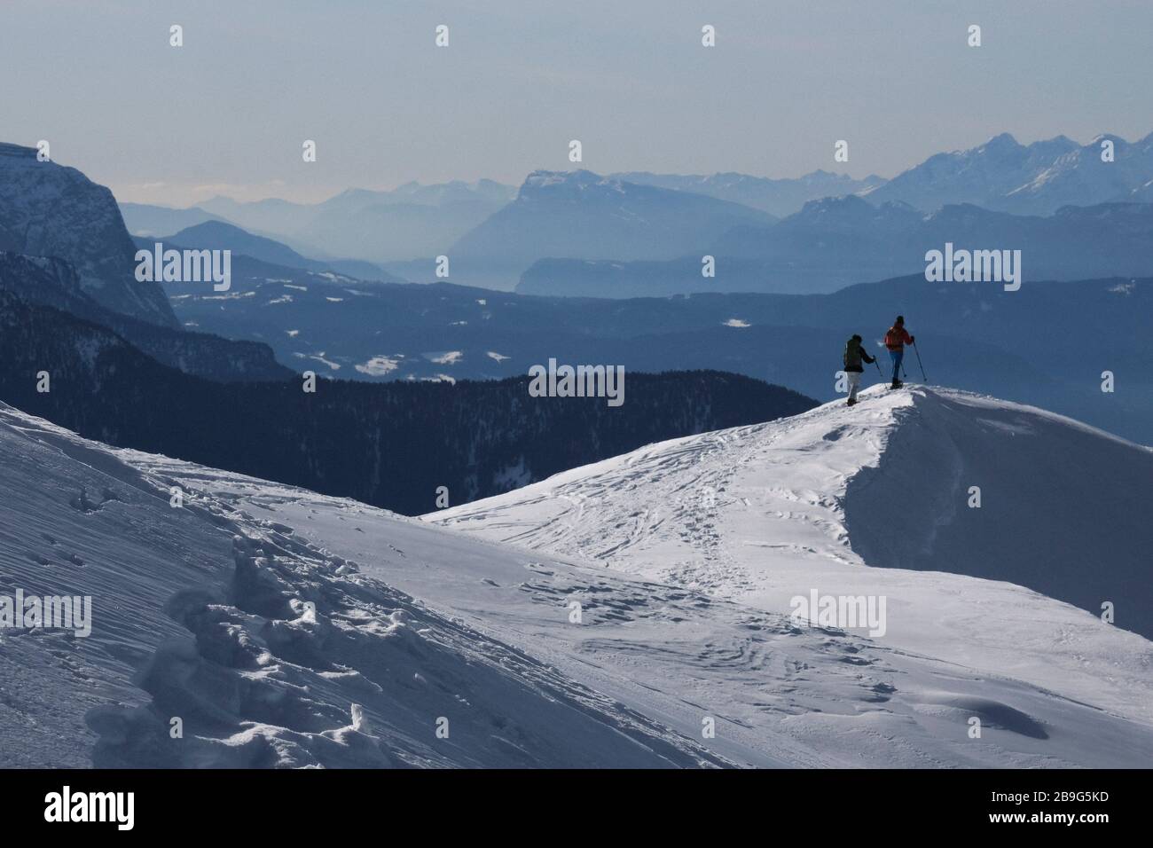 Pareja de senderismo en la soleada, pintoresca montaña nevada, Brixen, Tirol del Sur, Italia Foto de stock
