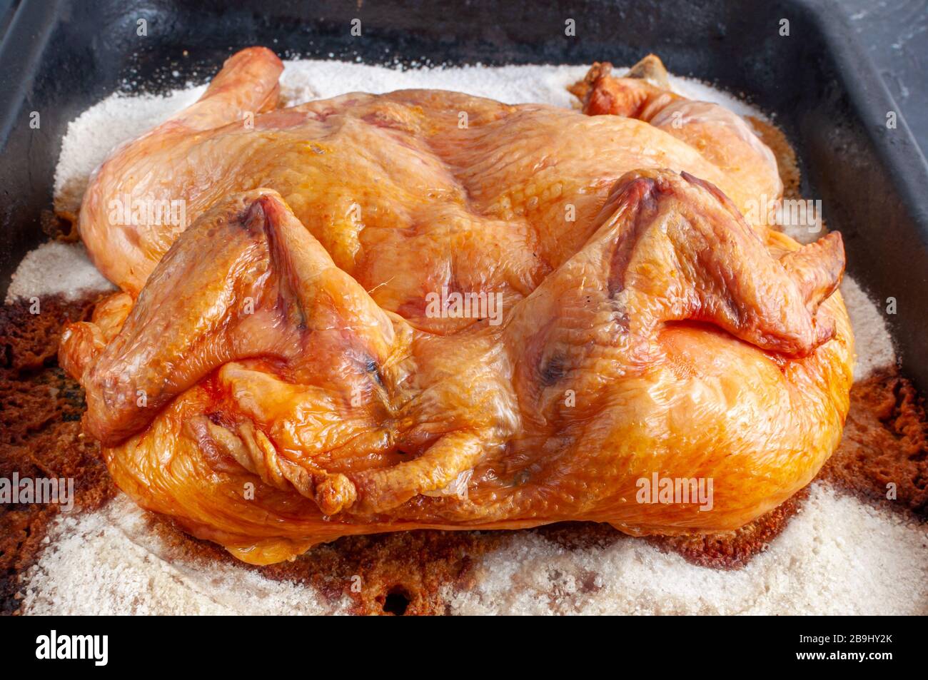 Pollo horneado en el horno sobre una gruesa capa de sal en una bandeja  metálica Fotografía de stock - Alamy