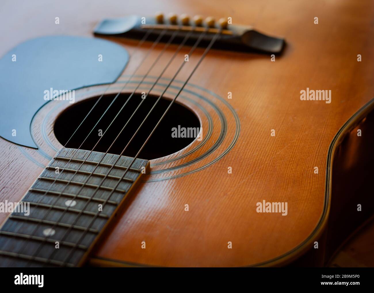 Guitarra acústica. Vista superior para parte del cuello y el cuerpo con  parte superior de madera, agujero de sonido, cuerdas y pasadores de puente  Fotografía de stock - Alamy