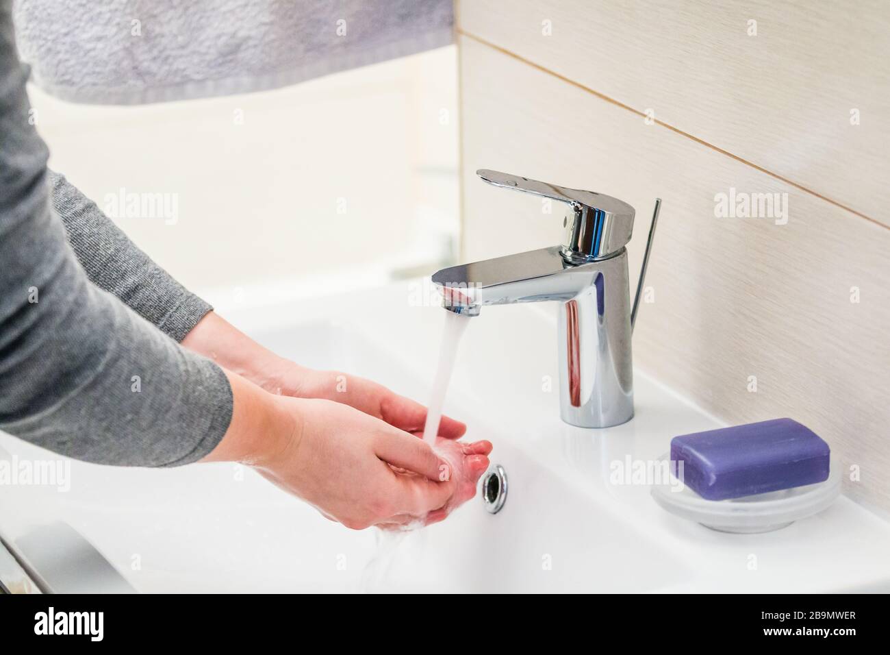 Lavado de manos con jabón sobre lavabo en el baño, primer plano. Foto de stock
